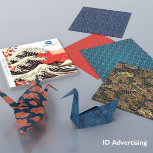 Kolorowe papiery origami i złożone żurawie prezentujące tradycyjne japońskie wzory fal i motyw&oacute;w, wraz z broszurą Konica Minolta zatytułowaną 'Giving Shape to Ideas
